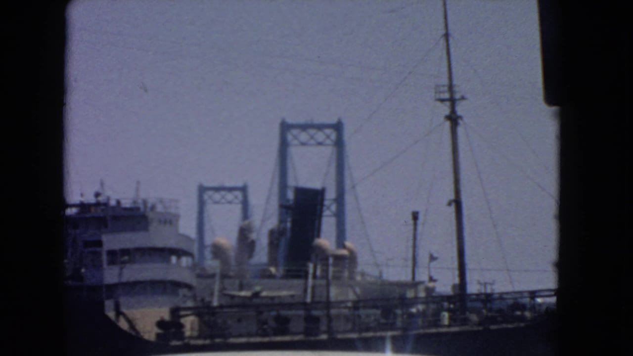 Raised drawbridge towers behind a ship, with poles and rigging lines crossing the sky.