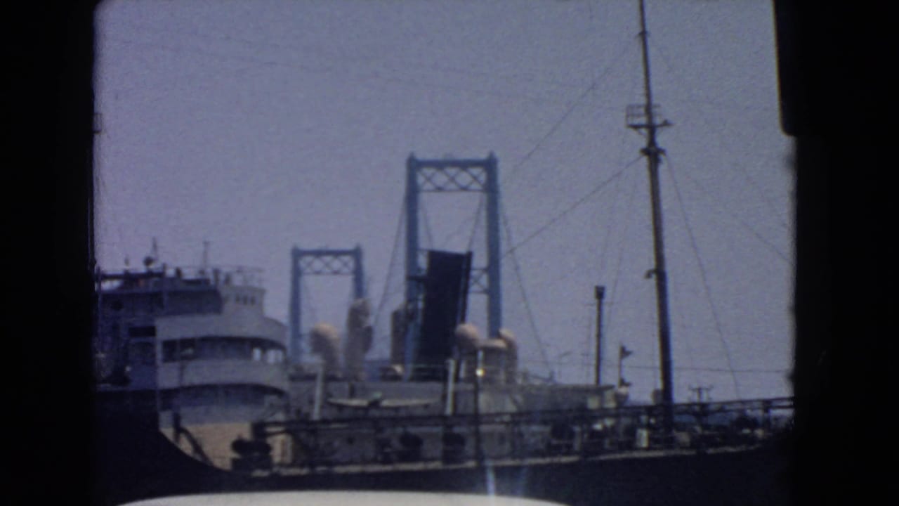 1966 San Pedro harbor shot with the ship lower in frame and the raised drawbridge centered beyond it.