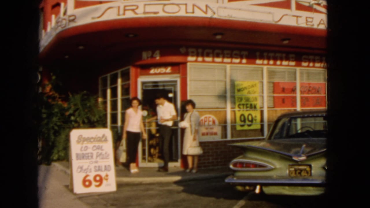 1966 San Pedro diner exterior with three adults near the entrance, red-and-white signage, food price boards, and a green 1960s car.