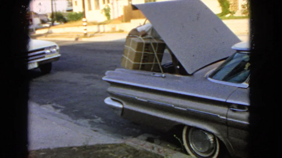 By the end of the San Pedro home-movie shot, the large wrapped box sits inside the open trunk of the silver car.