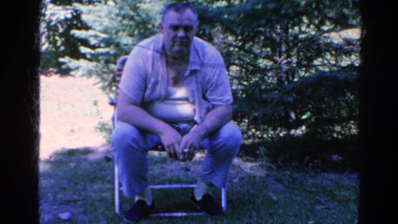 Adult man seated on a folding chair in a Silver Lake backyard, filmed on 8mm home-movie footage from 1966.