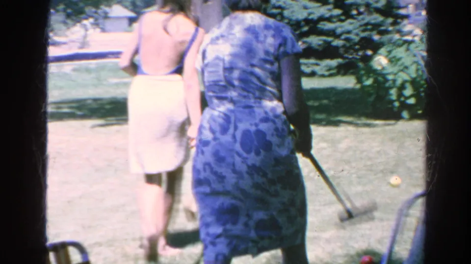 1966 Silver Lake backyard footage shows two women walking away across the grass, with one carrying a croquet mallet.