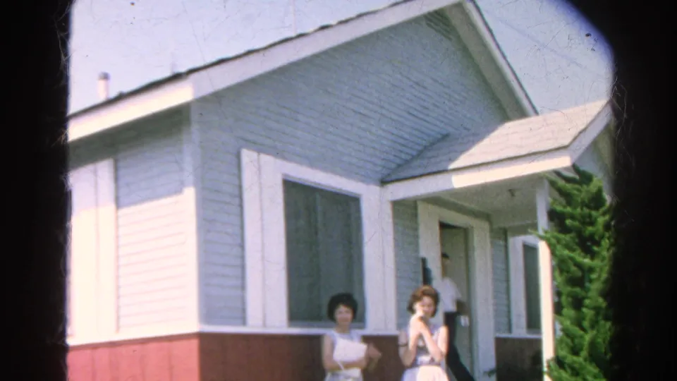 1966 Silver Lake home-movie frame showing two women outside a porch with another adult partly visible inside the doorway.