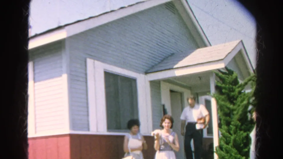 1966 Silver Lake frame with two women in the foreground and an adult man emerging from the porch doorway beside shrubs.