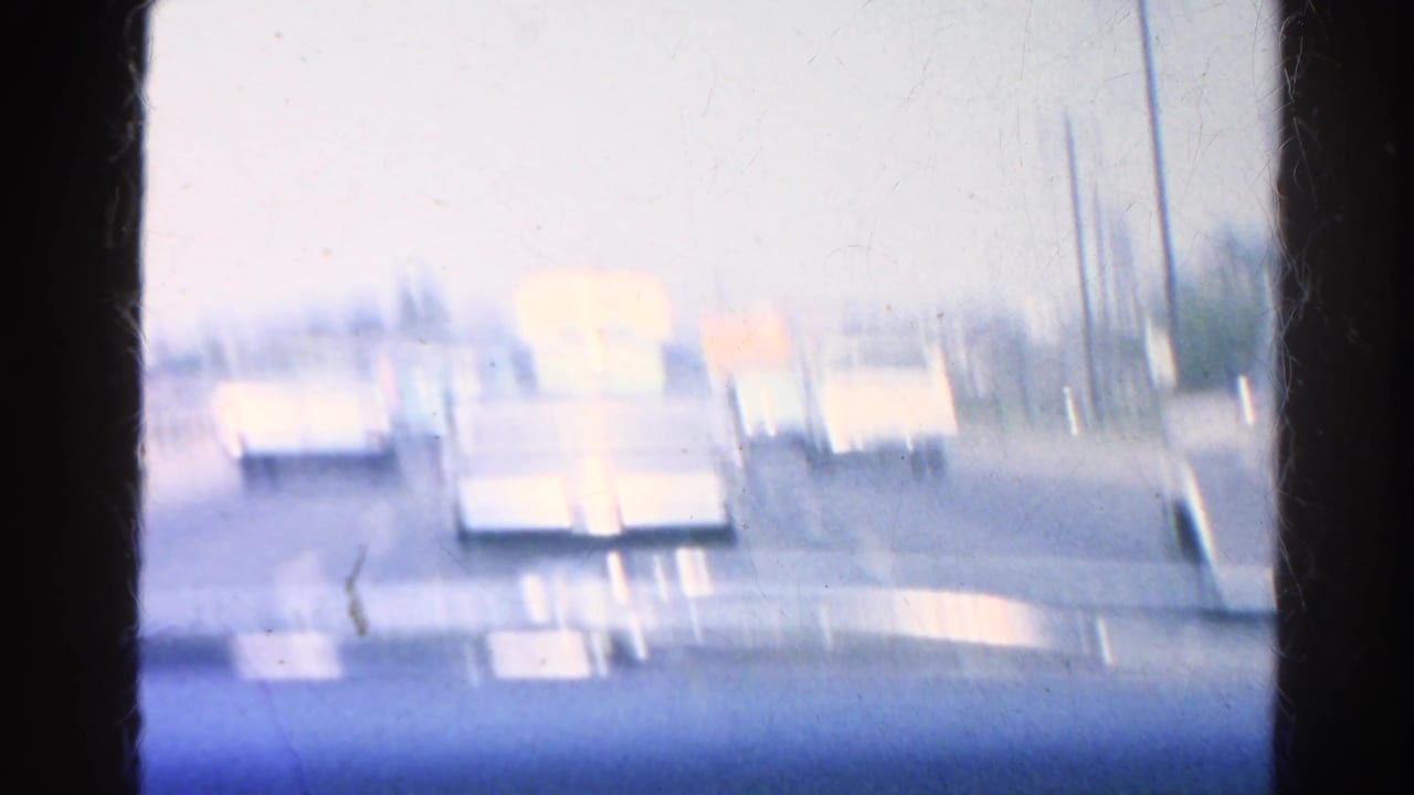 View through a car windshield toward slow-moving traffic on a multi-lane road.