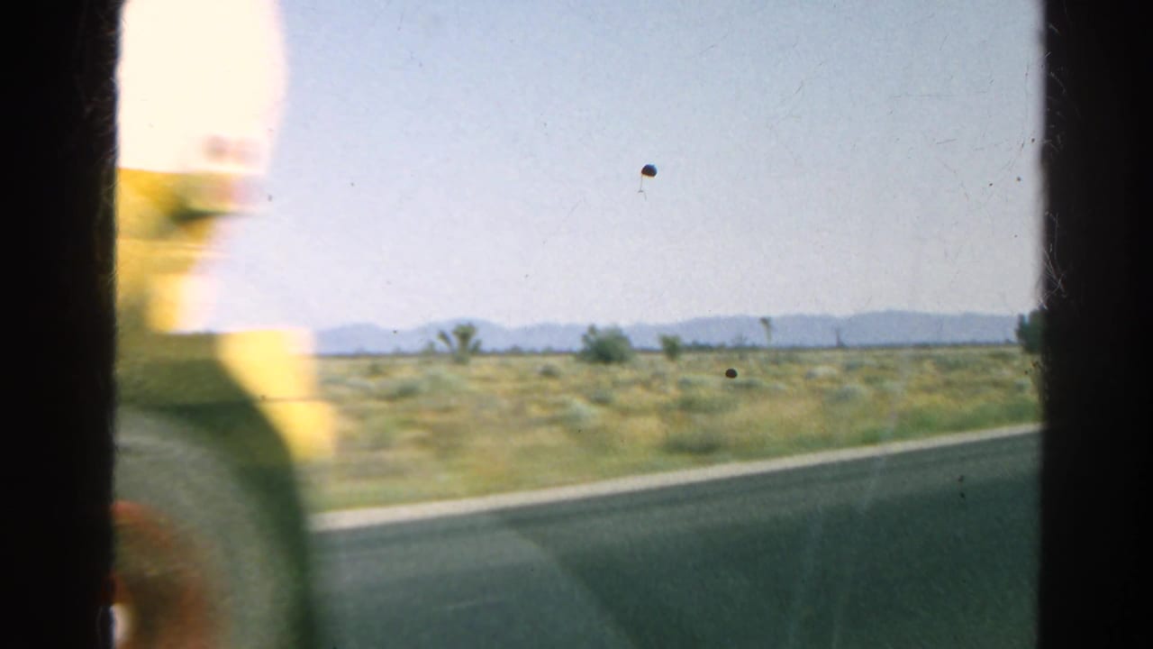 Blurred yellow tanker truck passing beside a desert highway from a moving vehicle.