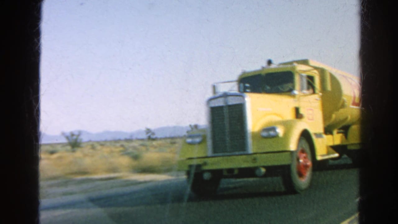 Yellow Shell tanker truck seen from a moving vehicle on a sunlit California desert highway in 1966 home-movie footage.