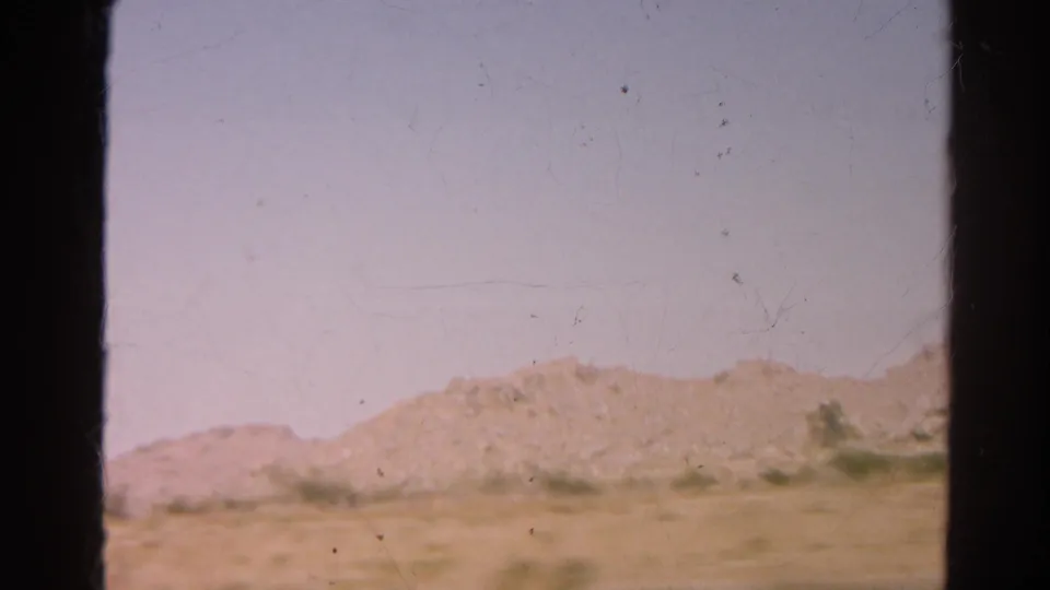 1966 8mm view near Silver Lake, California, showing a dry roadside, low hills, pale sky, and dark scan borders.