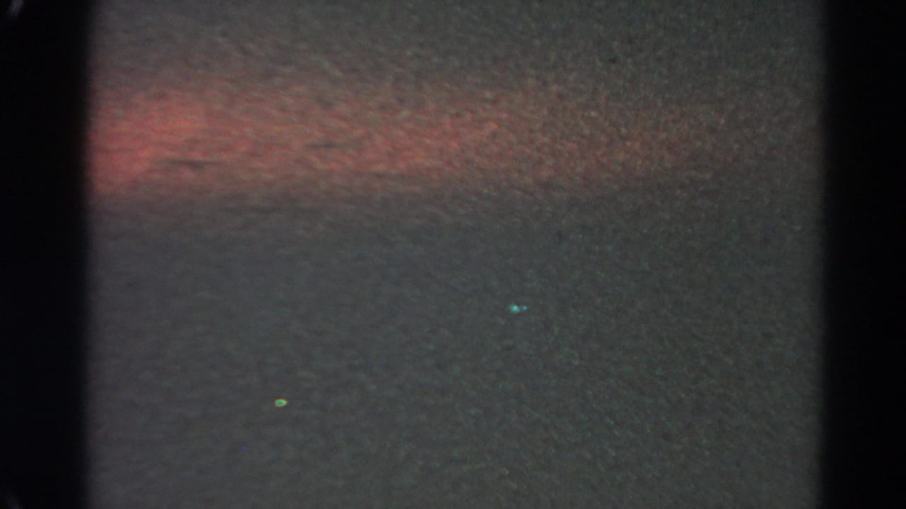 1966 Silver Lake 8mm frame showing a dark night sky, reddish-orange horizontal glow, and scattered small green-yellow lights.