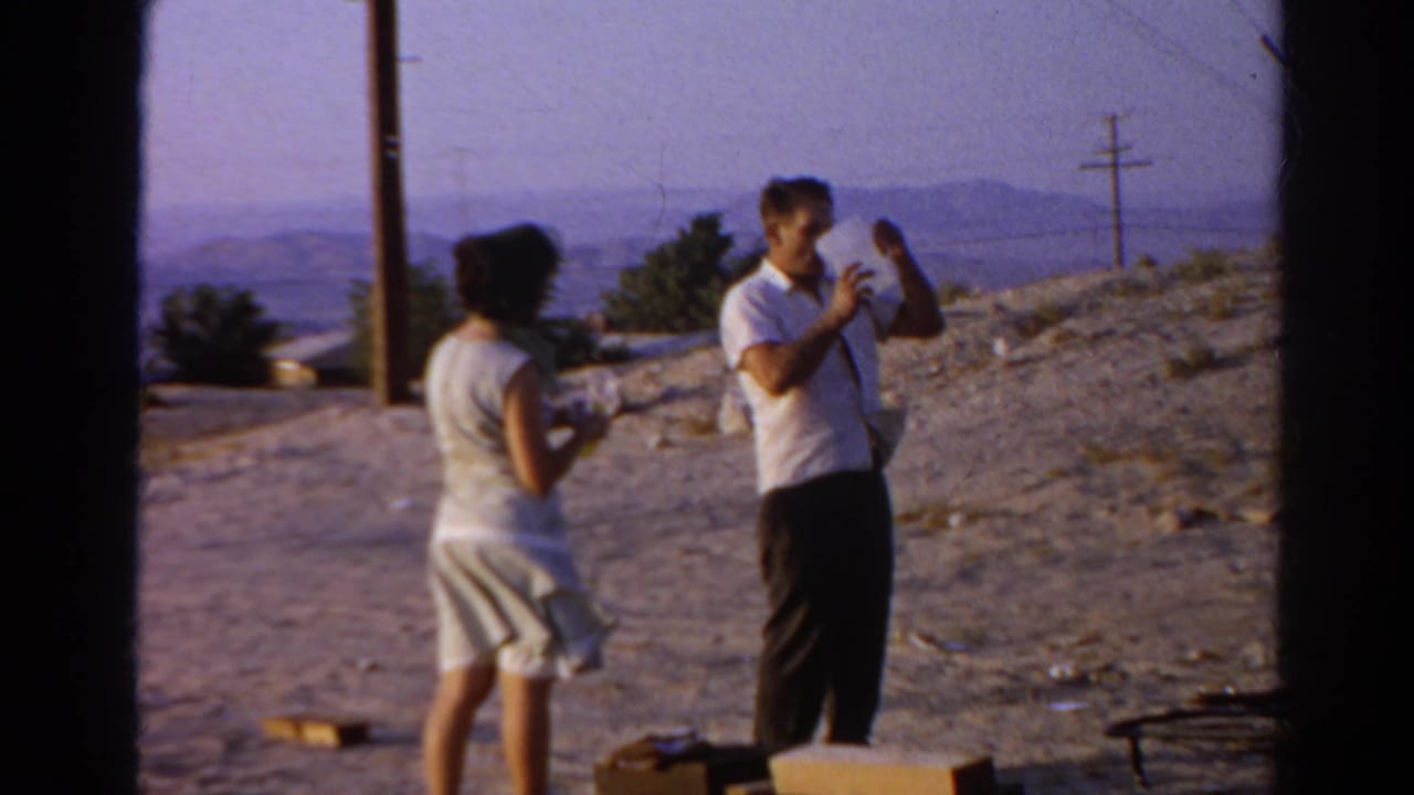 In 1966 Silver Lake home-movie footage, a man raises a jug while a woman stands nearby on a dry hillside site.