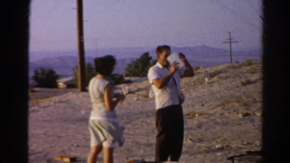 The man continues holding the jug as the woman stands across from him at the Silver Lake hillside site.