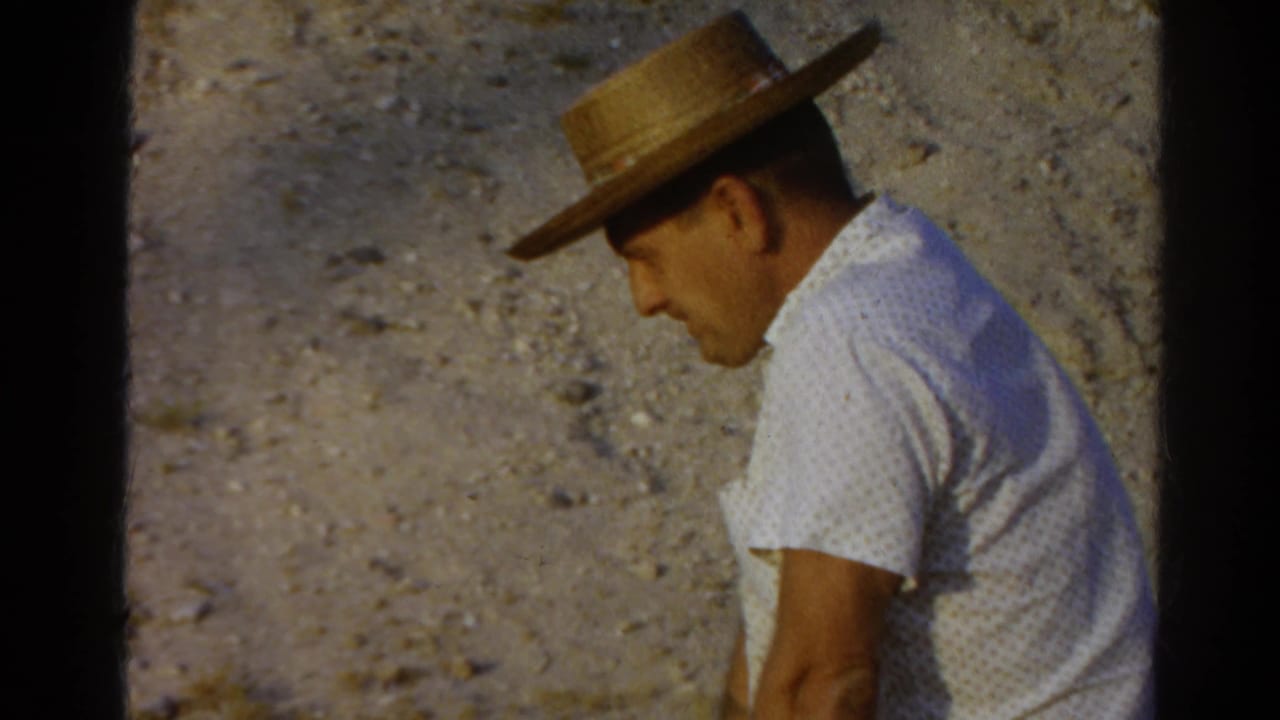 A seated man in a straw hat and white patterned shirt appears turned slightly away in this 1966 Silver Lake 8mm frame.