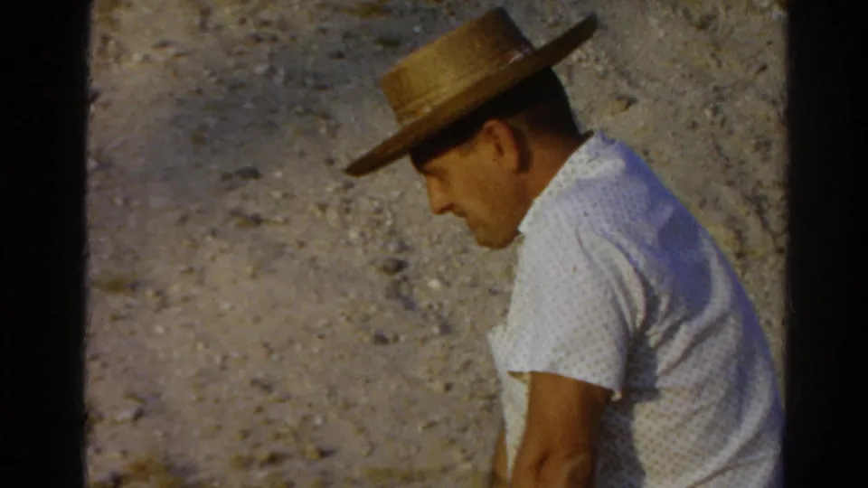 A seated man in a straw hat and white patterned shirt appears turned slightly away in this 1966 Silver Lake 8mm frame.