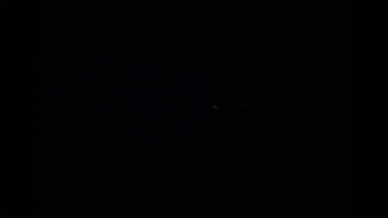 Dark 1966 Silver Lake home-movie frame with barely visible distant lights against a black sky.
