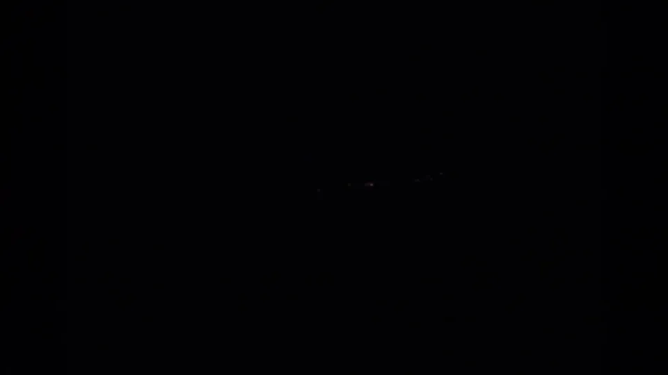 Dark 1966 Silver Lake home-movie frame with barely visible distant lights against a black sky.