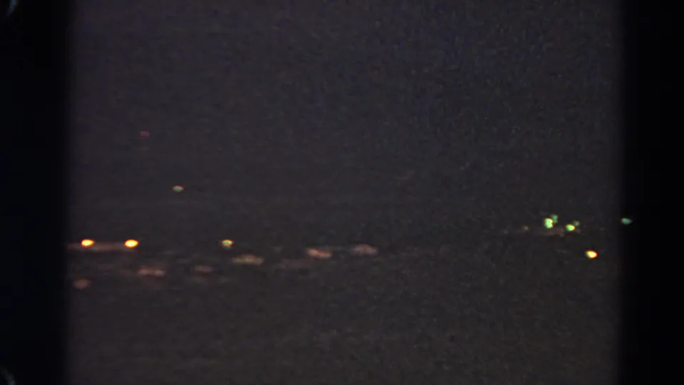 1966 8mm Silver Lake night view with distant warm city lights scattered across a dark horizon.