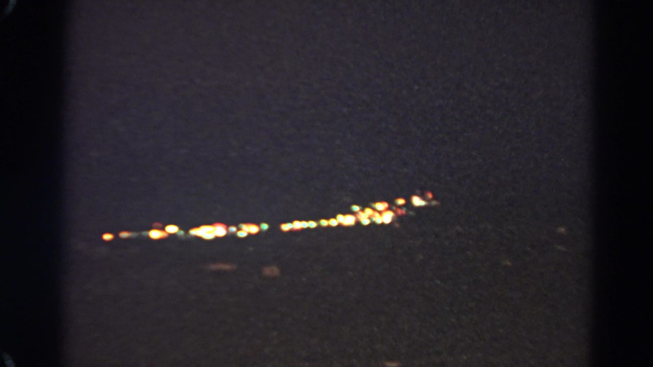 Silver Lake 1966 night frame with elongated warm city lights and soft, grainy 8mm exposure.