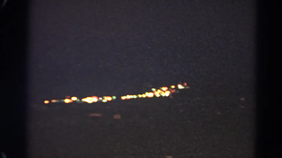 Silver Lake 1966 night frame with elongated warm city lights and soft, grainy 8mm exposure.