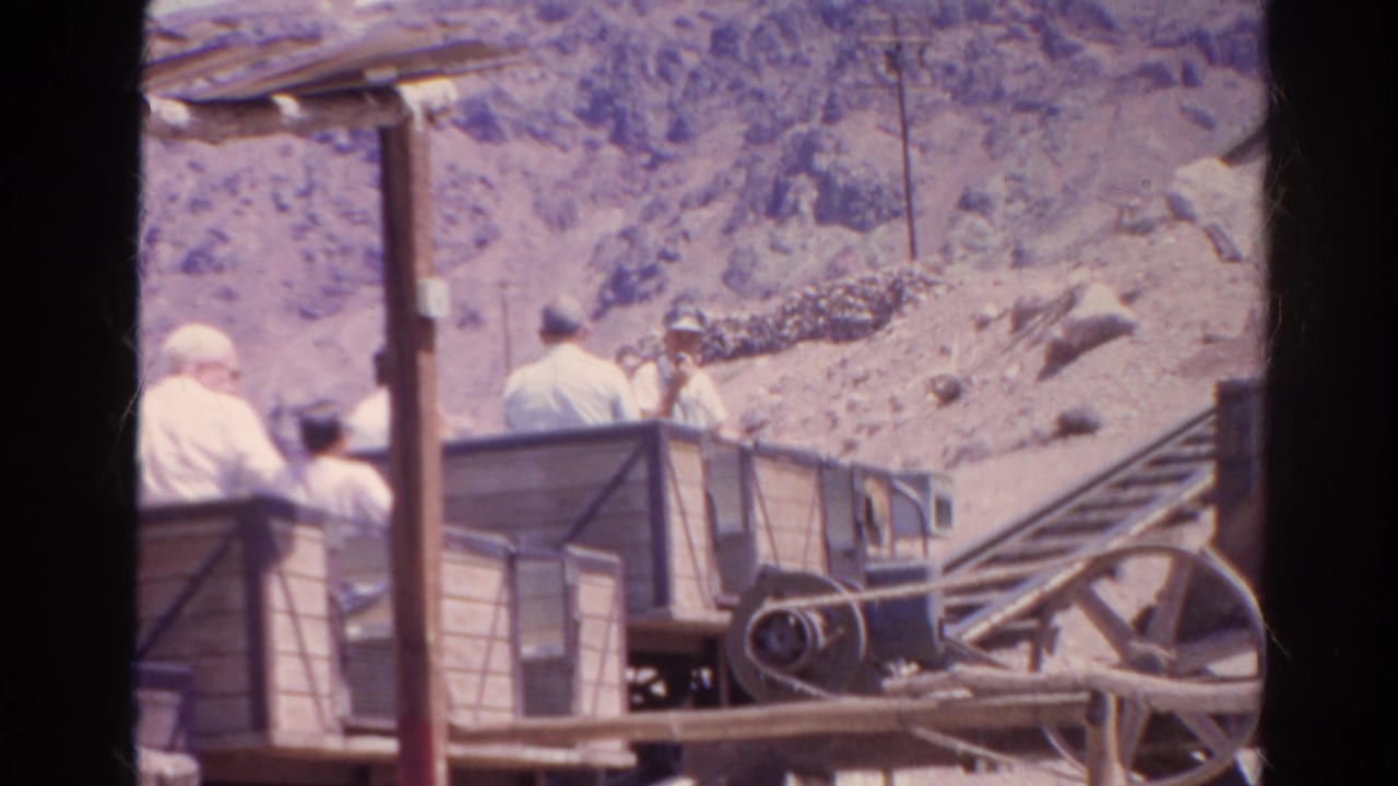 1966 Silver Lake, California footage showing several men riding a wooden cart up a dusty hillside with a pulley wheel and partial sign behind them.