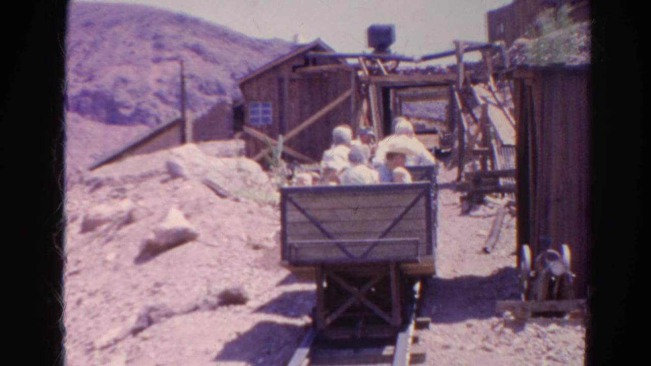 1966 Silver Lake, California home-movie frame showing visible riders in a wooden mining cart on narrow rails at a themed attraction.
