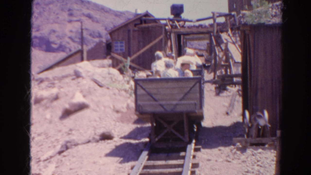 1966 Silver Lake, California frame showing riders in a wooden mining cart passing through a rustic mine-themed ride area.