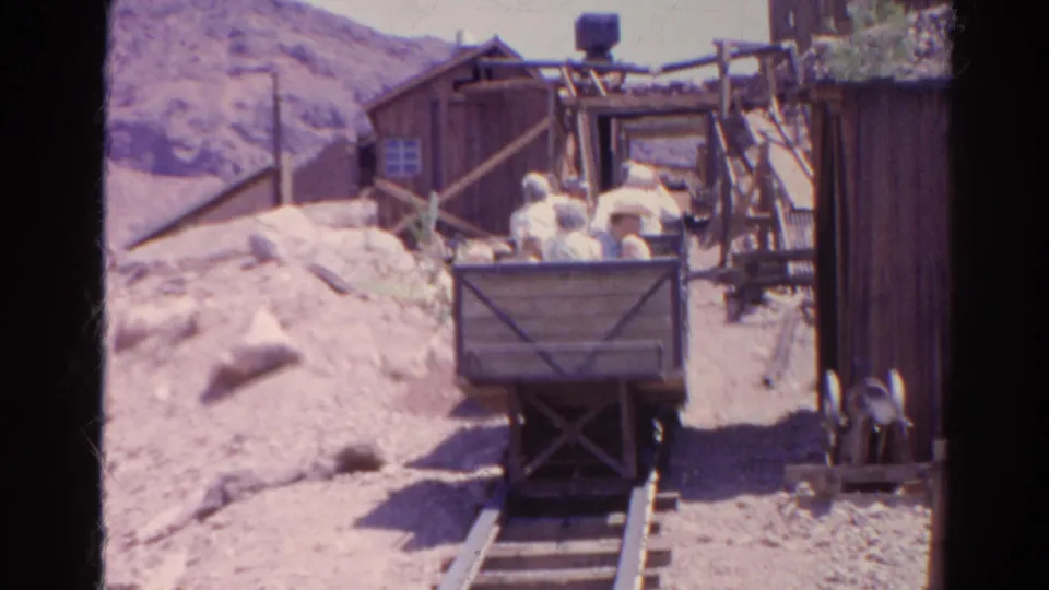 1966 Silver Lake, California frame showing riders in a wooden mining cart passing through a rustic mine-themed ride area.