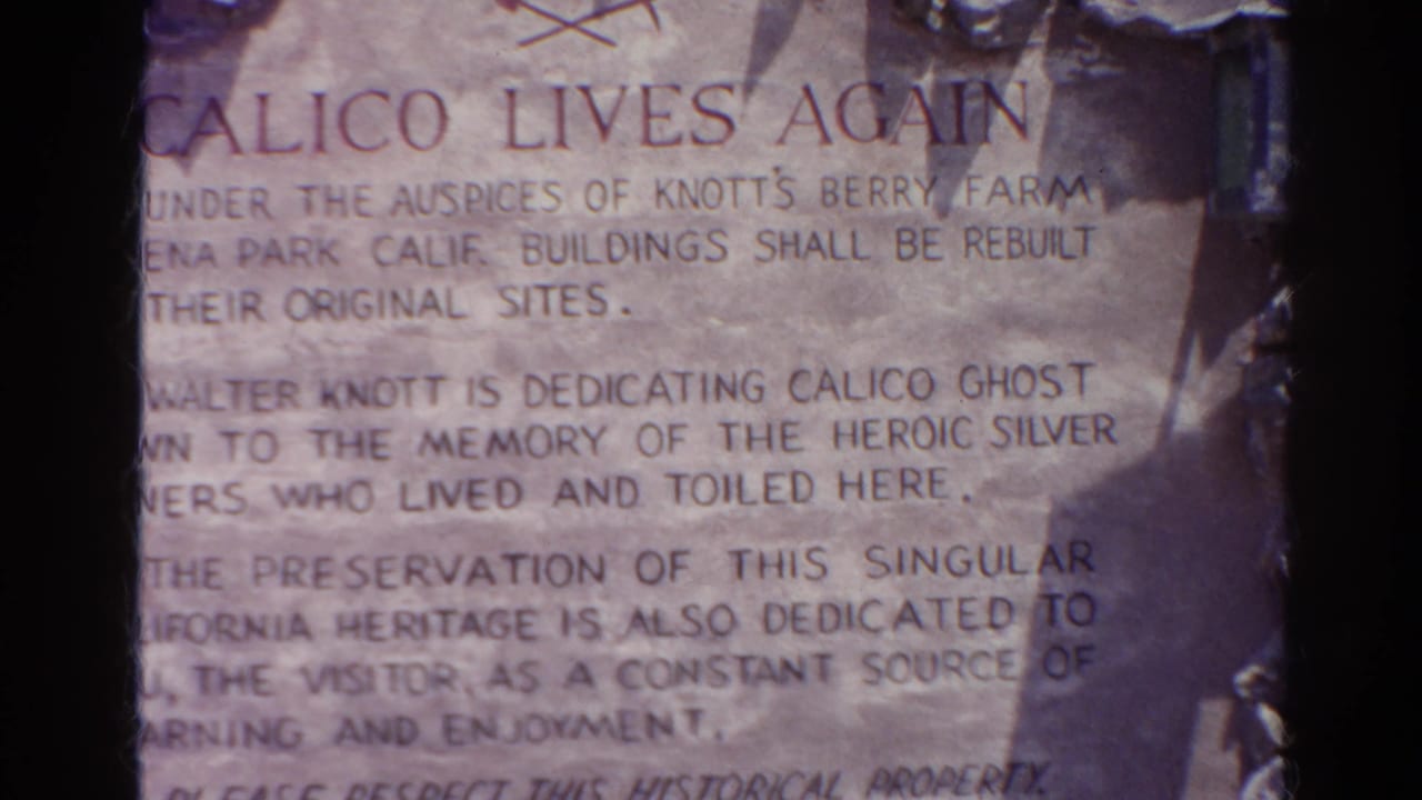 Close 1966 8mm view of a Calico Lives Again plaque describing preservation of a historic mining town site in California.