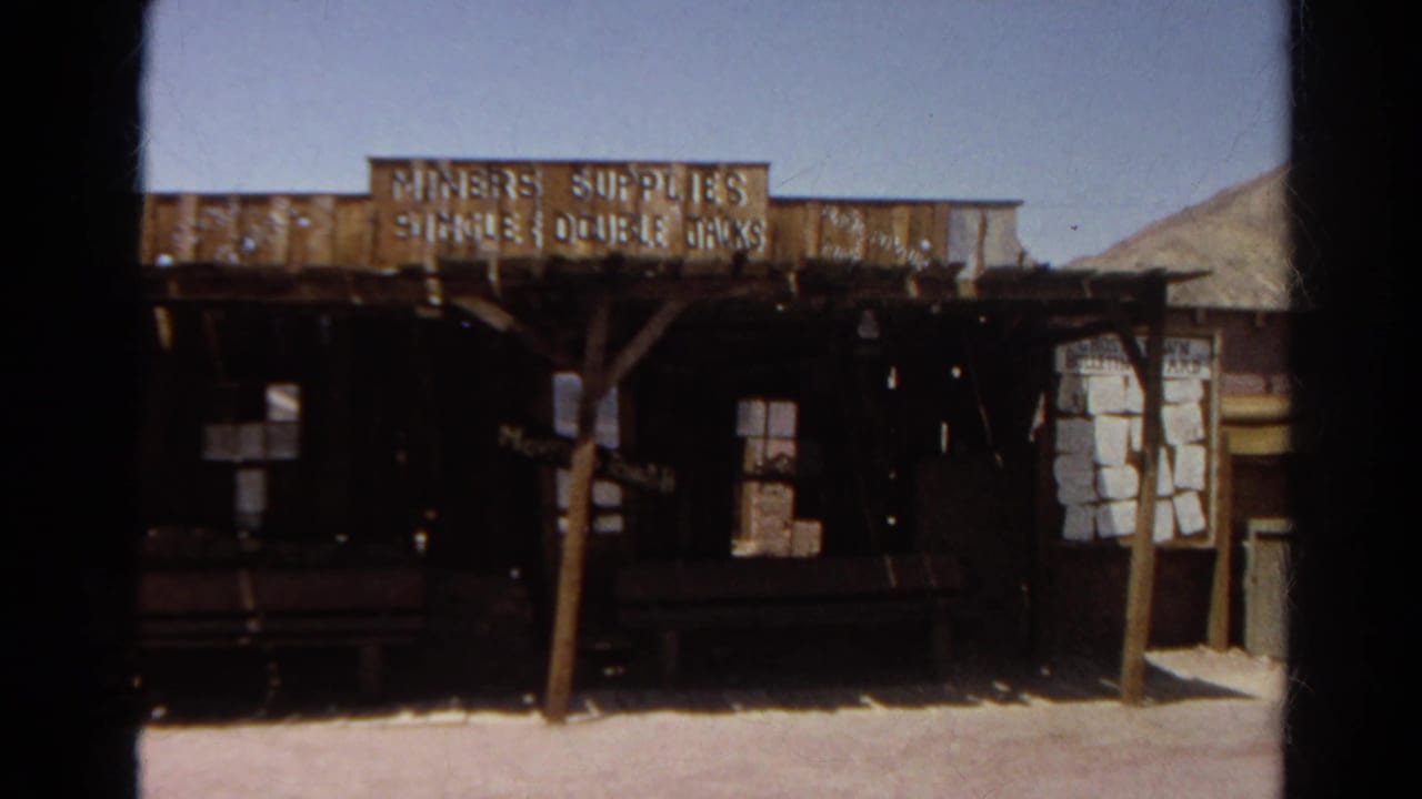 Rustic wooden storefront with a Miners Supplies sign under a clear sky.