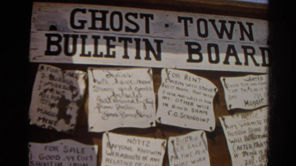 1966 8mm frame from Silver Lake, California, showing a weathered Ghost Town Bulletin Board with multiple pinned handwritten notices.