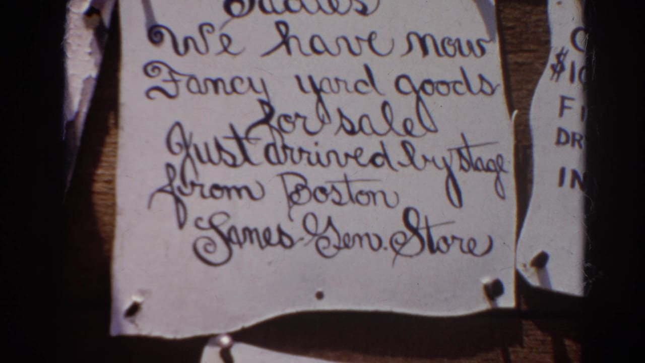 Close view of torn handwritten paper signs pinned to a wooden surface.