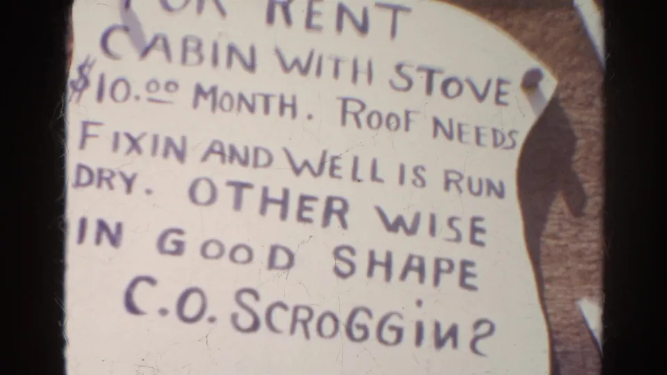 Close-up 1966 Silver Lake 8mm frame of a handwritten cabin-for-rent notice with stove, roof repair, and dry well details.