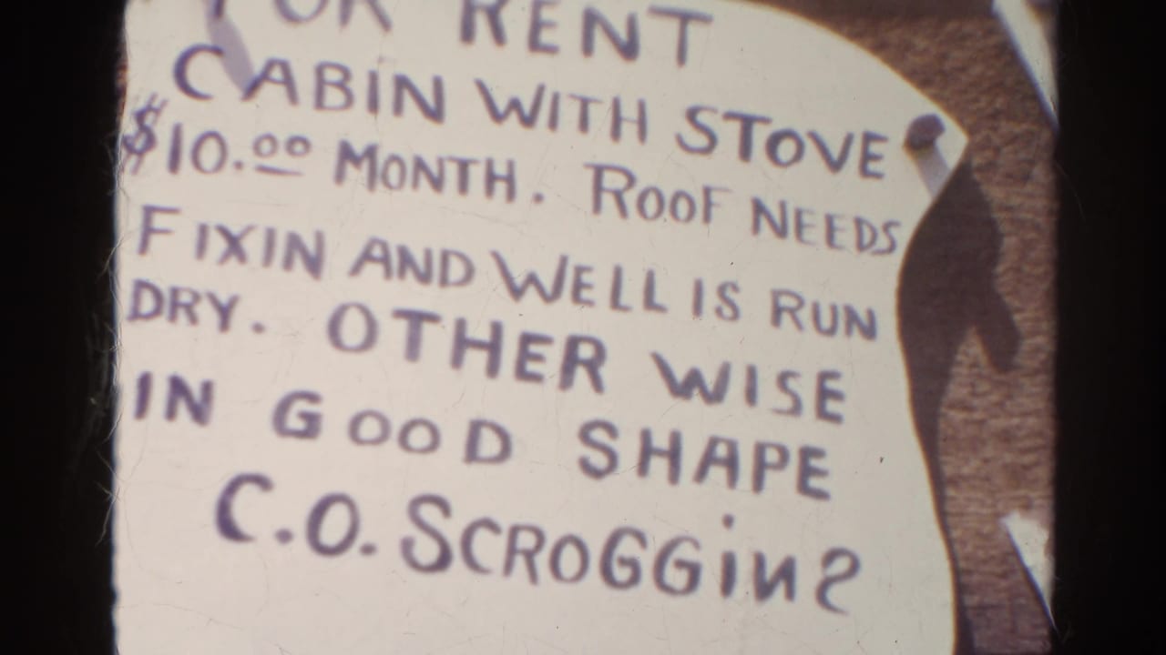 Silver Lake, California 1966 home-movie frame showing a handwritten cabin rental sign with stove, roof repair note, and C.O. Scroggin contact.