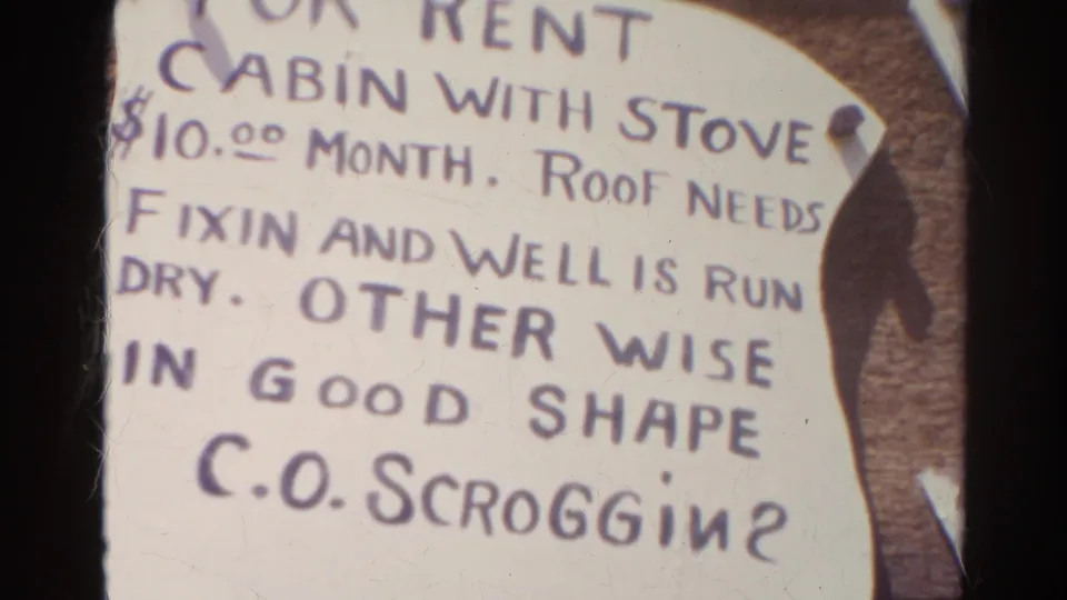 Silver Lake, California 1966 home-movie frame showing a handwritten cabin rental sign with stove, roof repair note, and C.O. Scroggin contact.