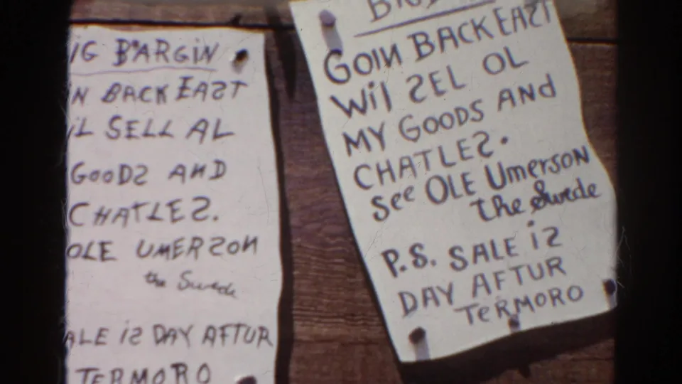 Archival 8mm frame from Silver Lake, California showing overlapping handwritten paper notices about goods and chattel, pinned to wood.