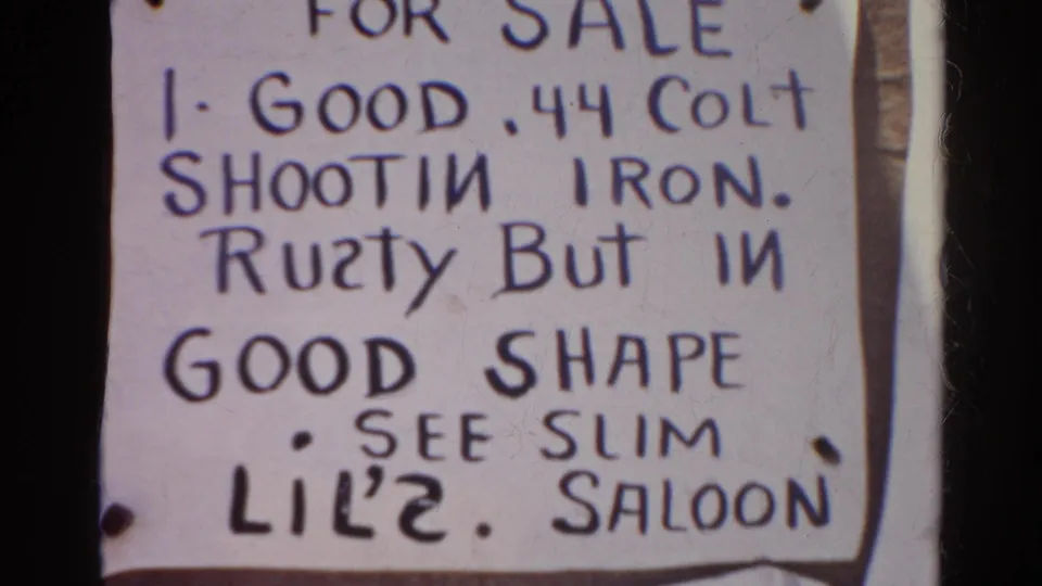 Close 8mm frame of the .44 Colt sale notice, showing the handwritten condition note and Lil'2 Saloon reference.