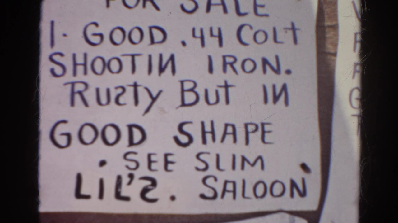 1966 Silver Lake 8mm frame showing a paper sign advertising a .44 Colt shooting iron, with rough lettering and pinned edges visible.
