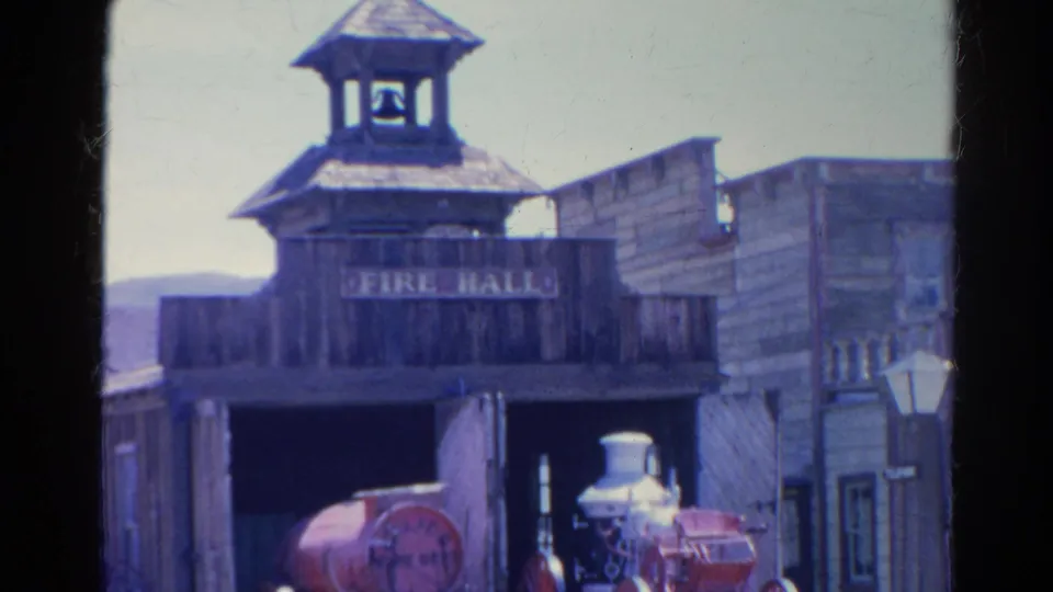 1966 Silver Lake footage showing an Old West-style wooden fire hall, bell tower, and red steam fire engine inside the open bay.