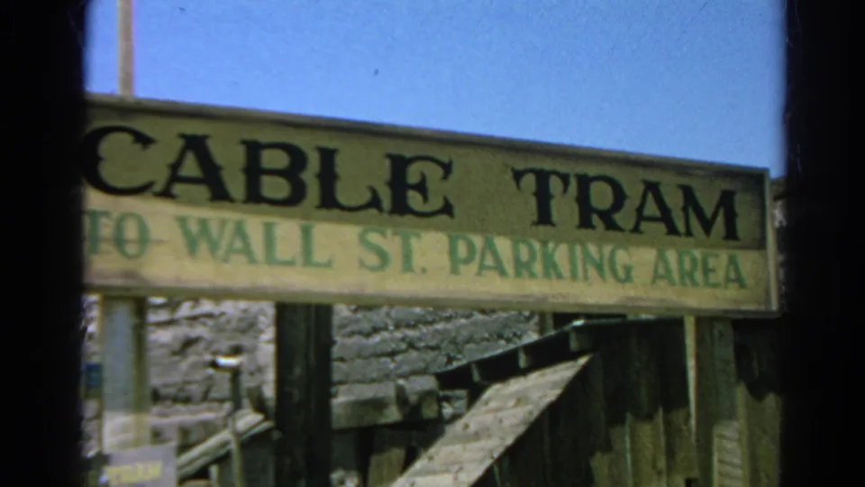 Final 1966 Silver Lake frame holding on the cable tram parking sign over rough wood structures and a sloped timber rail.