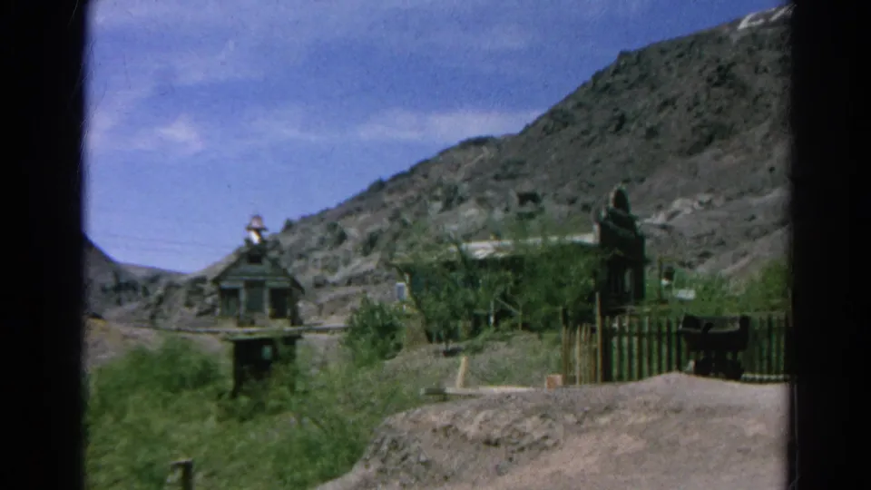 Silver Lake, California 8mm frame of an empty hill village area with a small towered structure, fencing, shrubs, and rugged slopes.