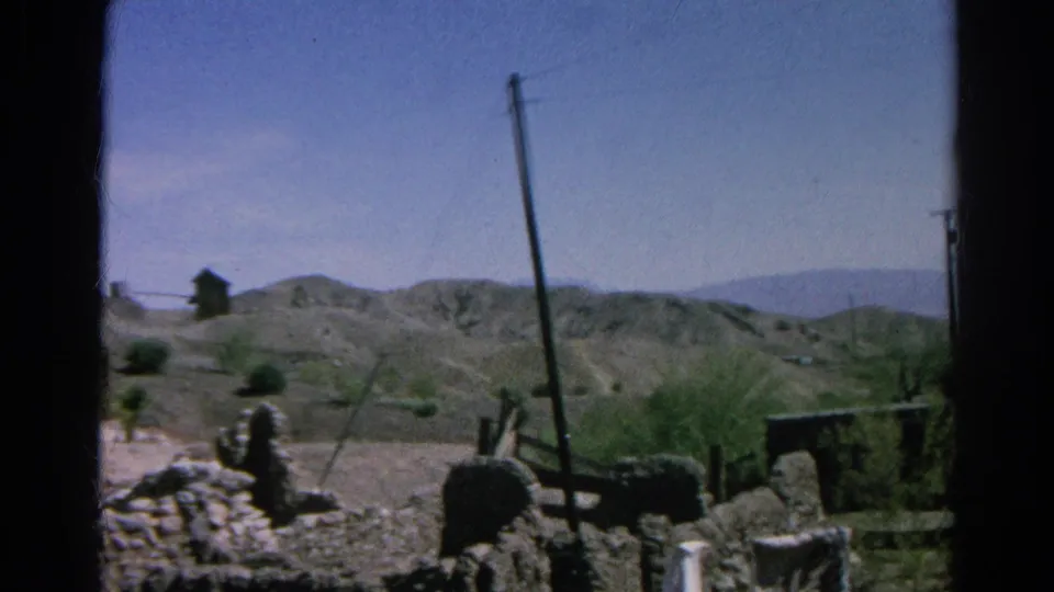 Final 1966 Silver Lake, California frame showing open dry terrain, rock walls, utility poles, shrubs, and distant hills.