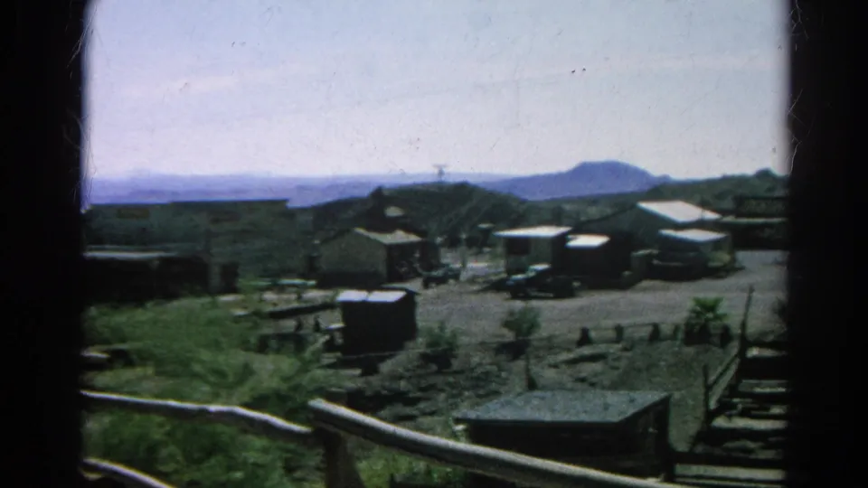 1966 Silver Lake residential overlook with modest homes, parked cars, fences, shrubs, and distant hills.