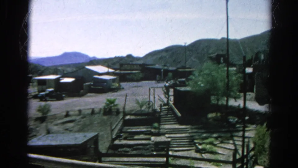 1966 Silver Lake residential frame showing hillside homes, parked vehicles, steps, railings, shrubs, and a utility pole.