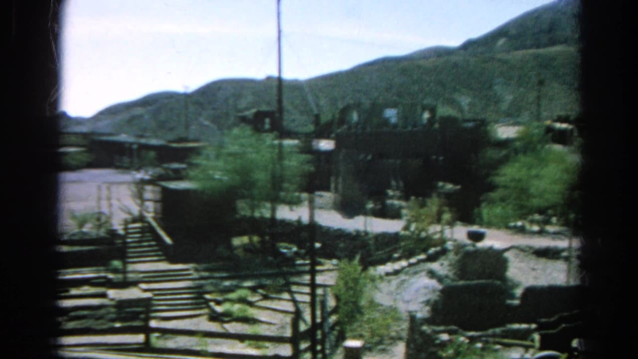 1966 Silver Lake, California frame of low settlement structures, steps, utility poles, roadways, scrub plants, and surrounding mountain slopes.
