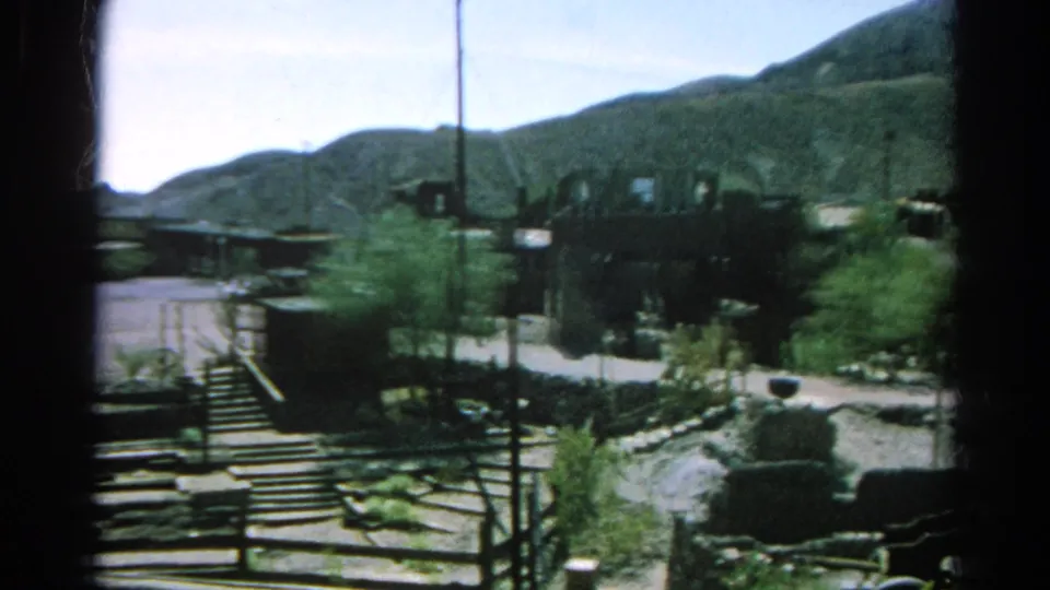 1966 Silver Lake, California frame of low settlement structures, steps, utility poles, roadways, scrub plants, and surrounding mountain slopes.