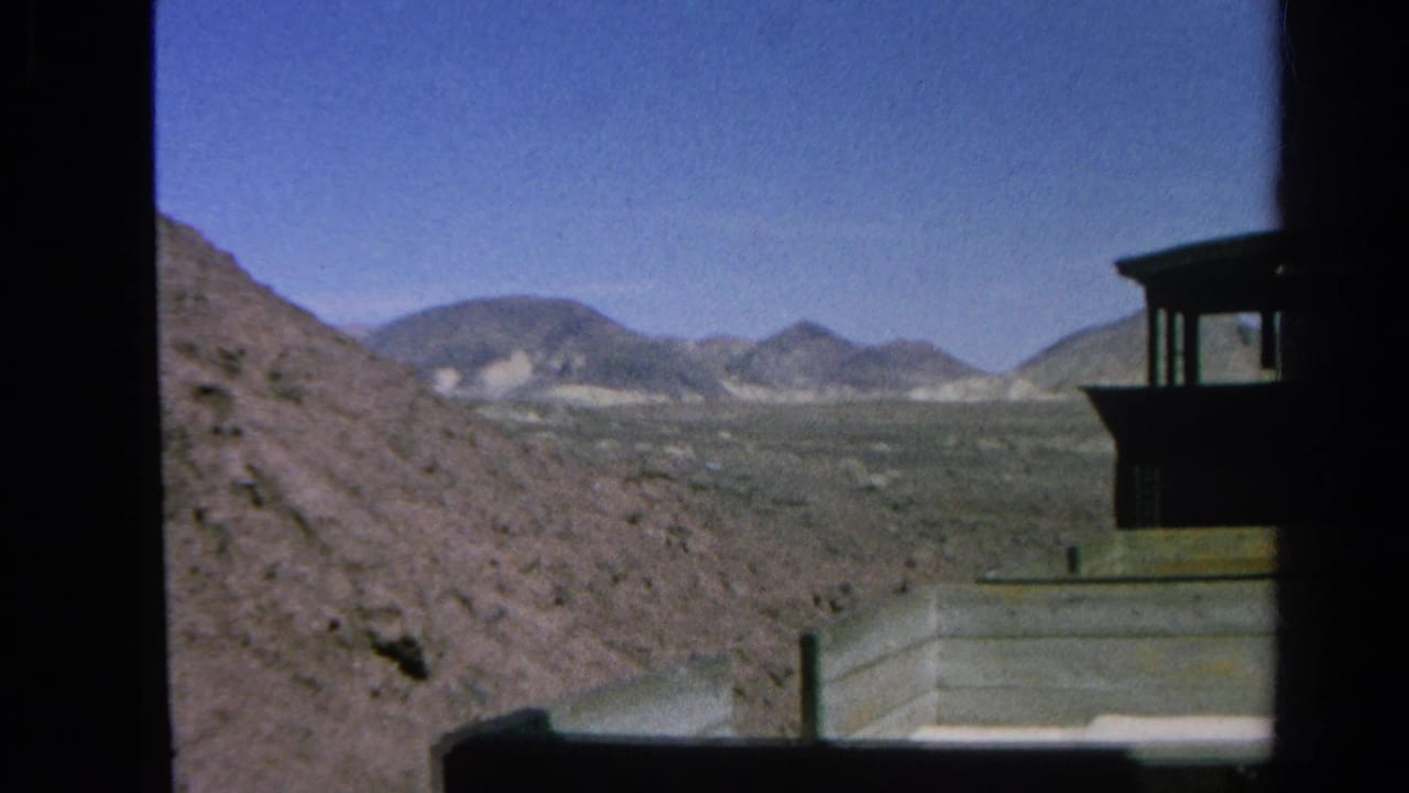The train cab exits the frame beside arid hills and distant mountains in this 1966 Silver Lake home-movie view.
