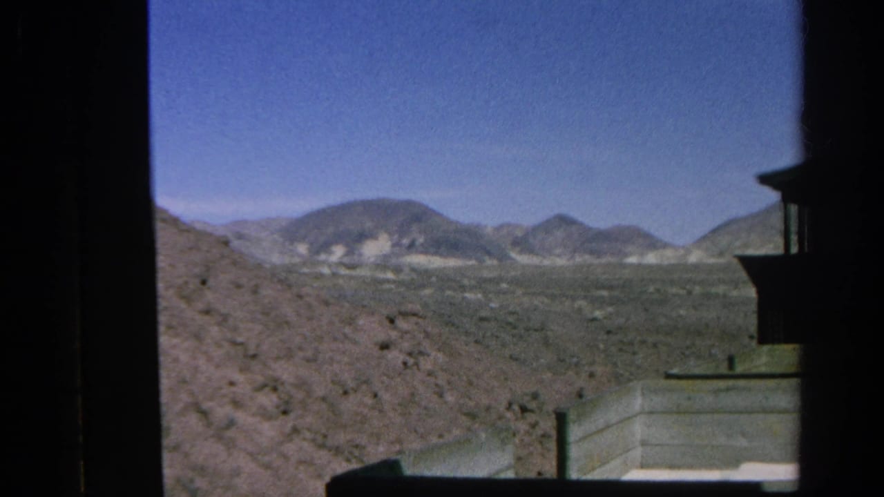 1966 8mm view from a train in Silver Lake, California, looking across dry hills and open desert terrain.