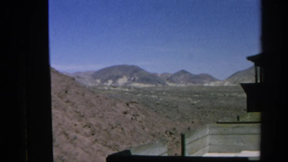1966 8mm view from a train in Silver Lake, California, looking across dry hills and open desert terrain.