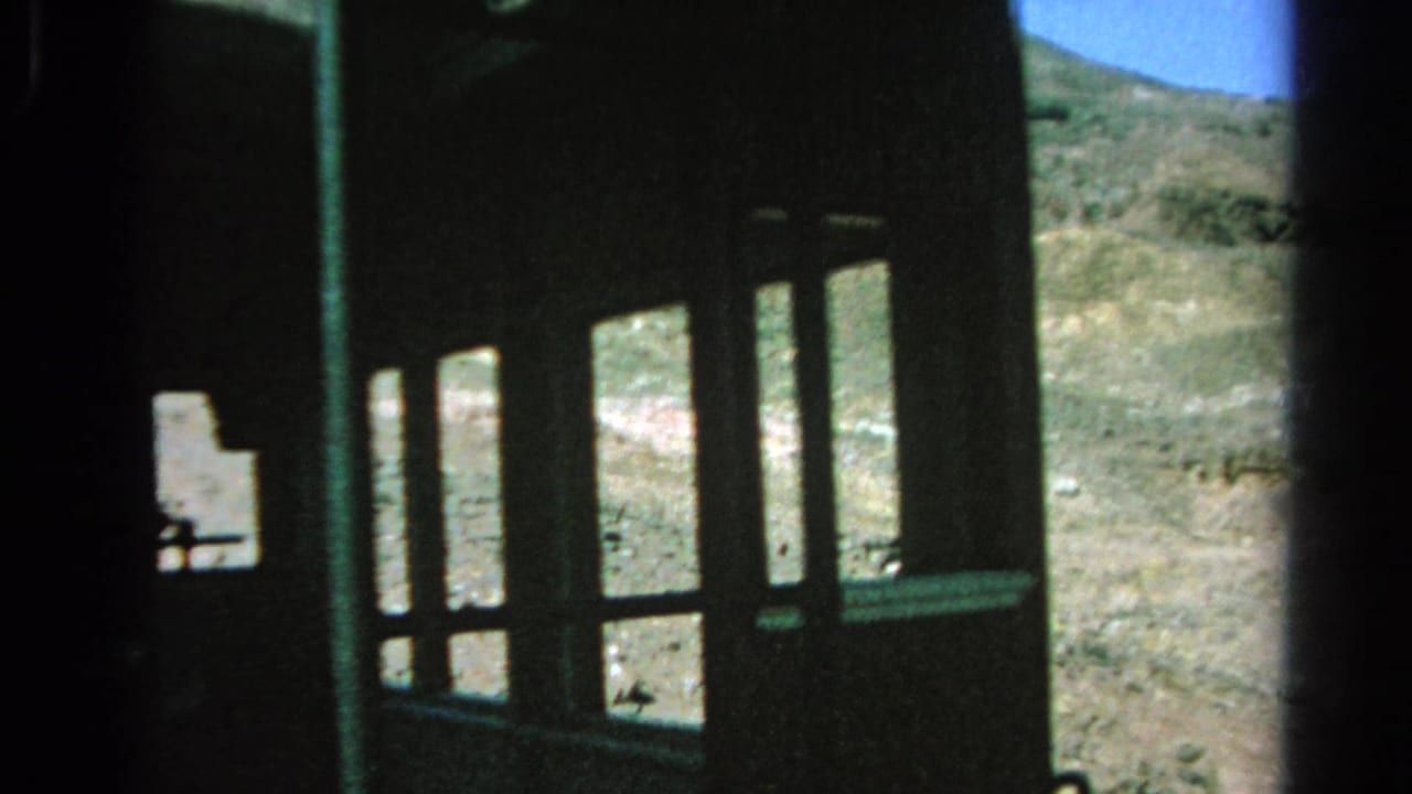 1966 8mm view from inside a funicular or incline car, with a dark window frame and barren Silver Lake hillside outside.