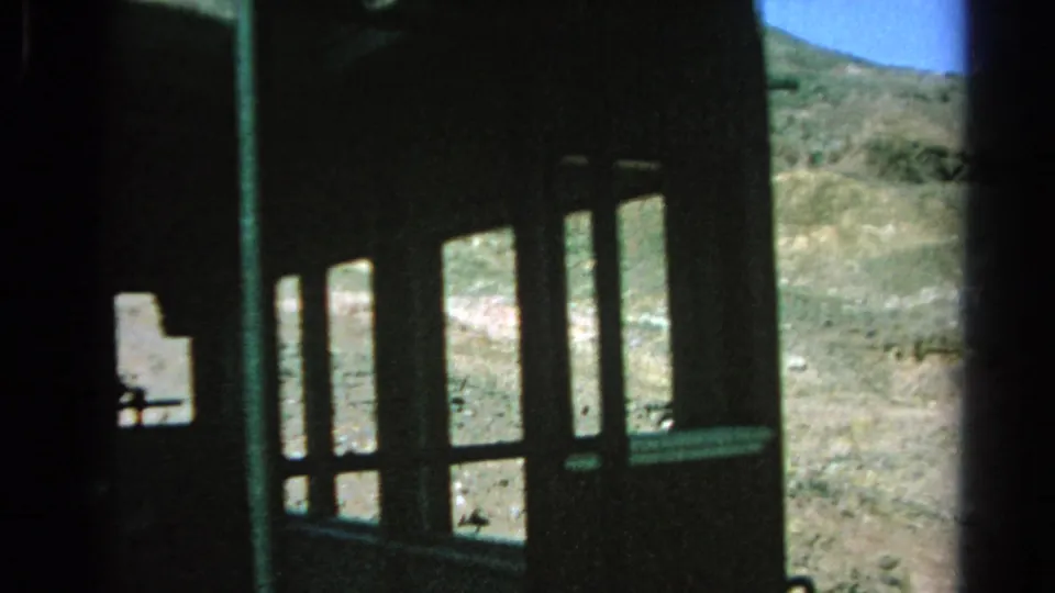 1966 8mm view from inside a funicular or incline car, with a dark window frame and barren Silver Lake hillside outside.