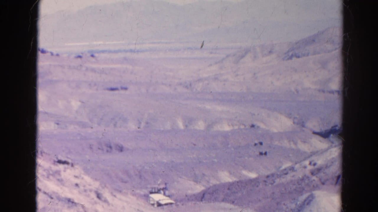Faded 8mm view of Silver Lake desert terrain, with a small structure or vehicle near a road at the lower edge of the frame.
